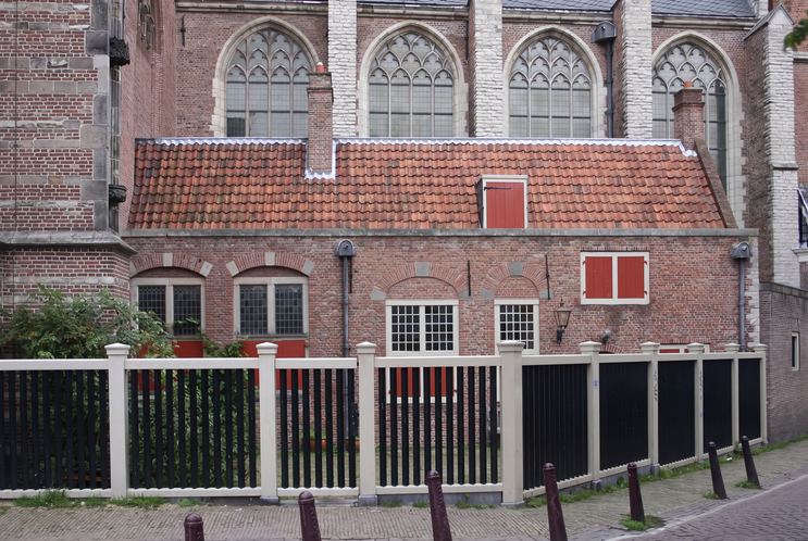 2004 — The sacristy fills the frame at last: red shutters, leaded cross-windows, relieving arches drawn back in brick — the “17th-century state” the restorers aimed for, a blend of three centuries that never quite coexisted. Nine years after this photograph, the coffee machines moved in.