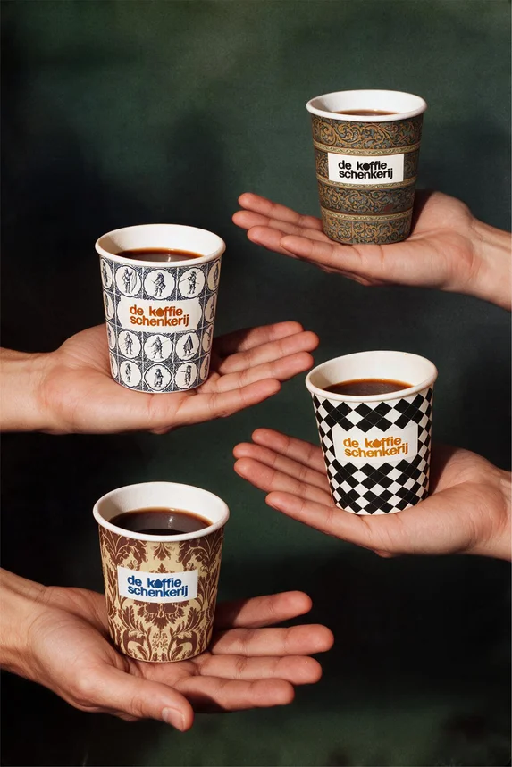Four branded cups balanced on outstretched hands against a dark green ground