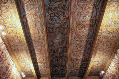 The painted beams of the sacristy ceiling, lit from below