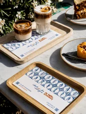 A tray of cards and lattes on a cafe table