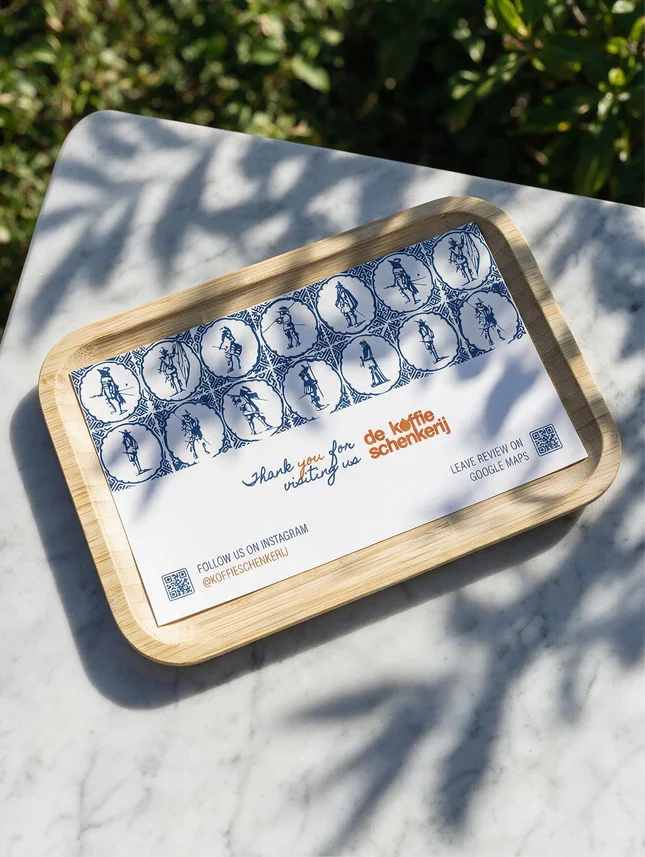 A Delft tile tray on marble in raking sunlight