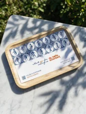 A Delft tile tray on marble in raking sunlight