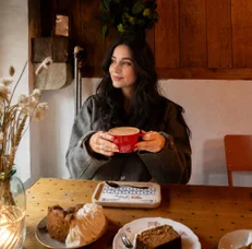 A guest with a red cup at a wooden table