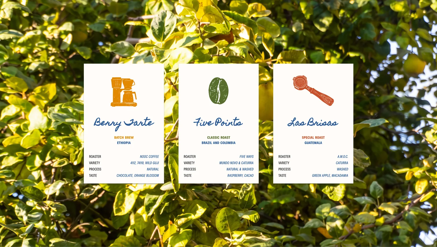 The three coffee menu cards — Berry Tarte, Five Points, Las Brisas — against foliage
