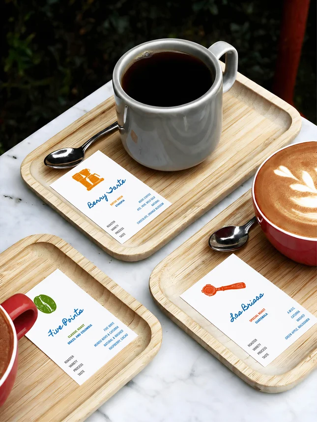 A cup of coffee on a tray beside a menu card