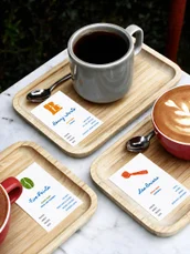 A cup of coffee on a tray beside a menu card