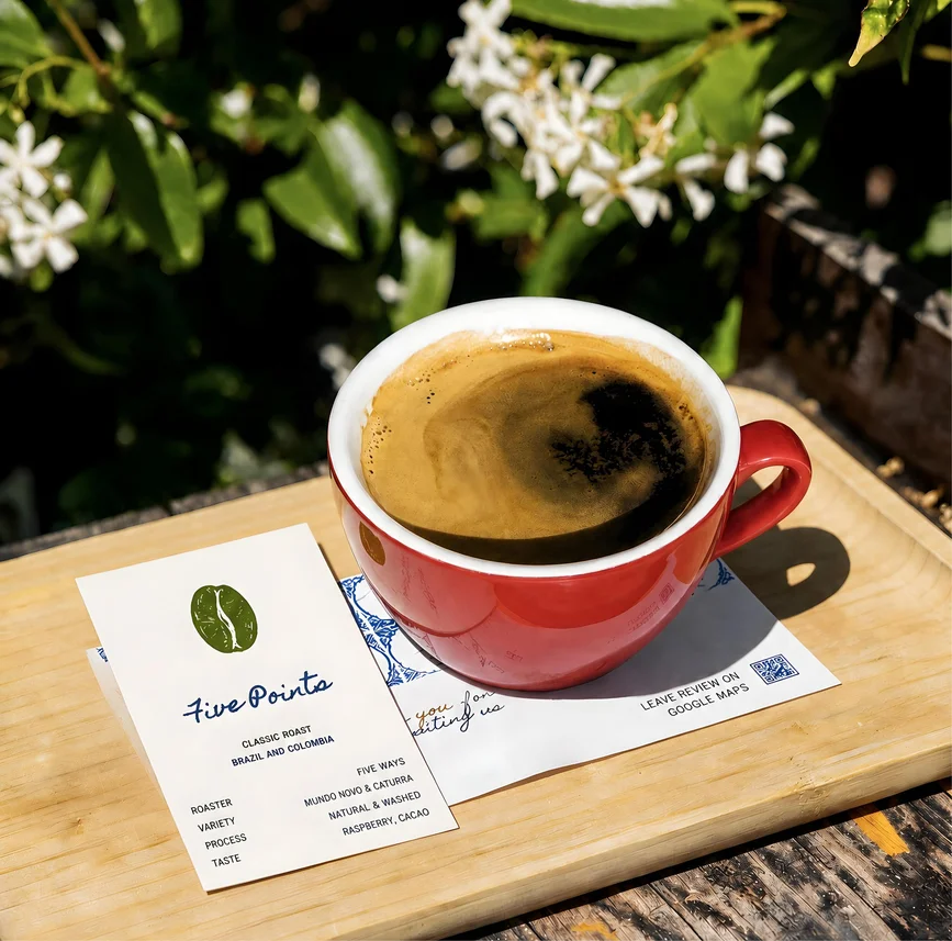A red cup and a business card on a tray outdoors