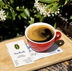 A red cup and a business card on a tray outdoors