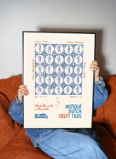 Someone holding up the framed Delft tile poster