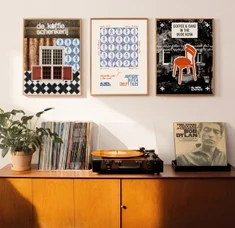 Framed posters on a shelf beside a record player