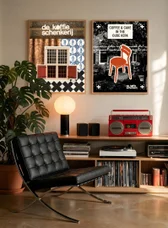 The posters hung in a living room with a leather chair